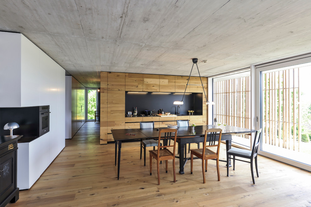 Große Moderne Wohnküche mit hellem Holzboden und weißer Wandfarbe in Mailand