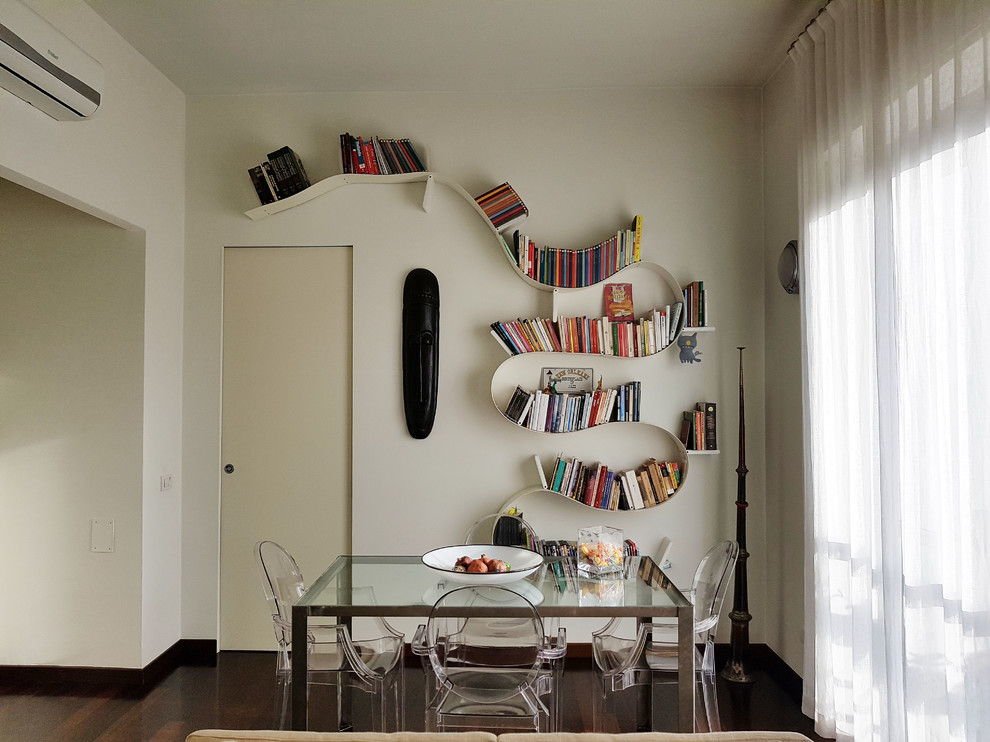 This is an example of a medium sized contemporary dining room in Milan with white walls and dark hardwood flooring.