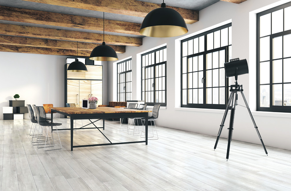 Immagine di un'ampia sala da pranzo aperta verso il soggiorno industriale con pareti bianche, pavimento in gres porcellanato e pavimento grigio