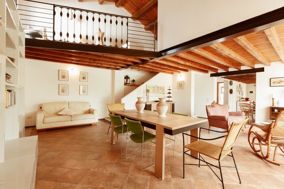 Esempio di una grande sala da pranzo aperta verso il soggiorno mediterranea con pareti bianche, pavimento in terracotta e pavimento rosa