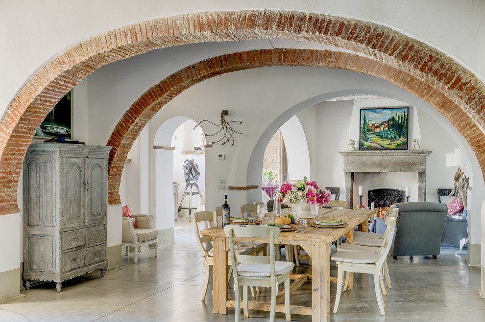 Idée de décoration pour une grande salle à manger méditerranéenne avec un mur blanc et sol en béton ciré.