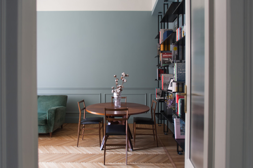 Photo of a small scandi enclosed dining room with blue walls, light hardwood flooring and beige floors.