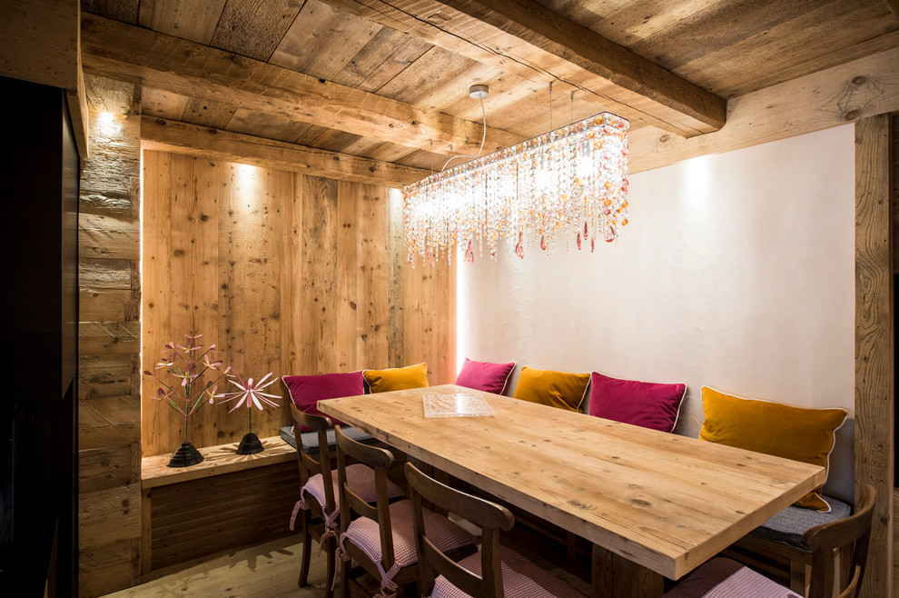 Immagine di una sala da pranzo rustica chiusa con pareti bianche e parquet chiaro