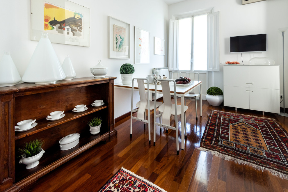 Immagine di una sala da pranzo aperta verso la cucina minimalista di medie dimensioni con pareti bianche, parquet scuro, camino ad angolo e pavimento marrone