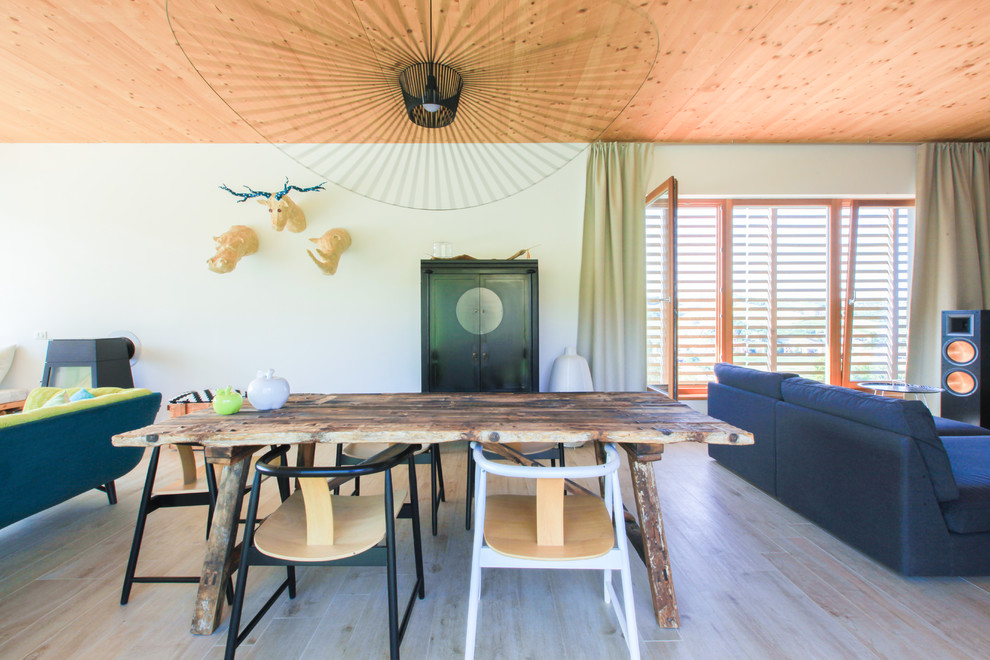 Immagine di una sala da pranzo aperta verso il soggiorno minimalista di medie dimensioni con pareti bianche, parquet chiaro e pavimento beige