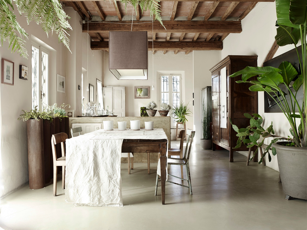 Esempio di una sala da pranzo aperta verso il soggiorno country con pavimento in cemento, pareti bianche e pavimento grigio