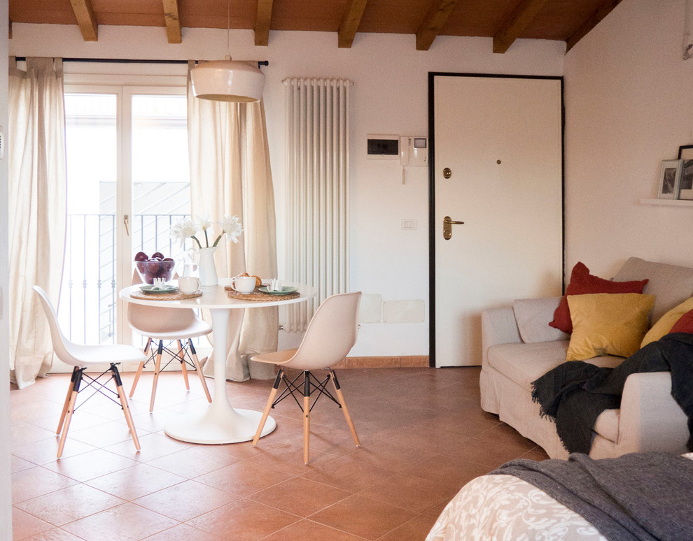 Источник вдохновения для домашнего уюта: маленькая гостиная-столовая в скандинавском стиле с белыми стенами, полом из терракотовой плитки и красным полом для на участке и в саду