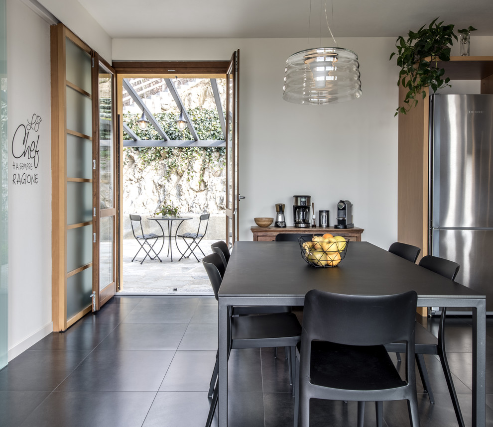 Ispirazione per una sala da pranzo aperta verso la cucina tradizionale di medie dimensioni con pareti bianche, pavimento in gres porcellanato e pavimento nero