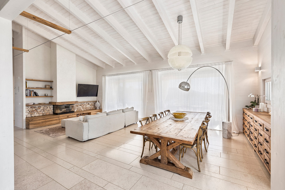 Immagine di una sala da pranzo aperta verso il soggiorno country con pareti bianche, camino lineare Ribbon e pavimento beige