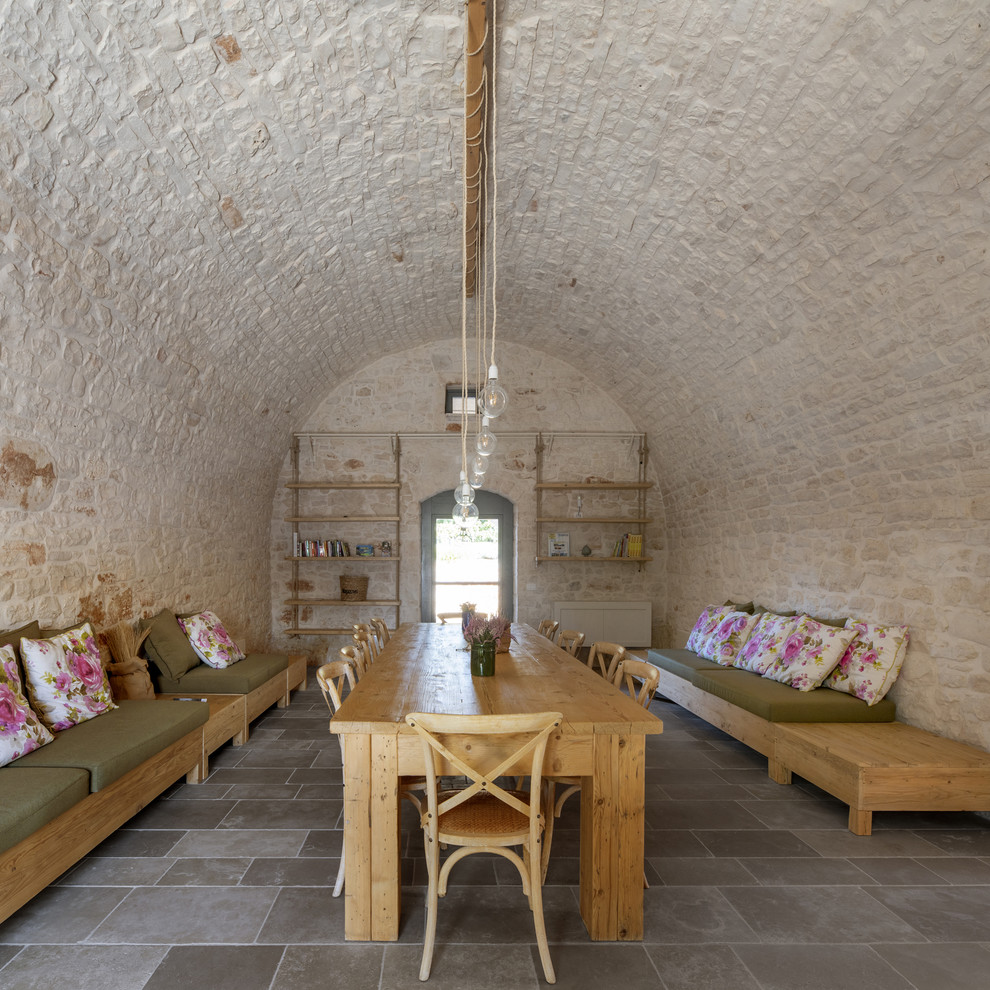 Idee per una sala da pranzo mediterranea con pareti bianche e pavimento grigio