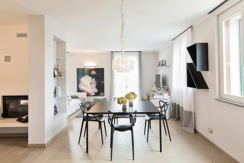 Idee per una sala da pranzo aperta verso il soggiorno minimal di medie dimensioni con pareti bianche, parquet chiaro, camino bifacciale e pavimento marrone