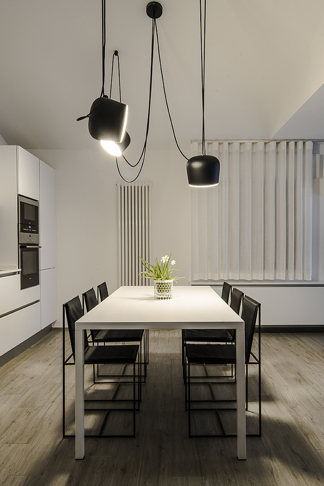 Idée de décoration pour une salle à manger minimaliste de taille moyenne avec un mur blanc, un sol en carrelage de porcelaine et un manteau de cheminée en plâtre.