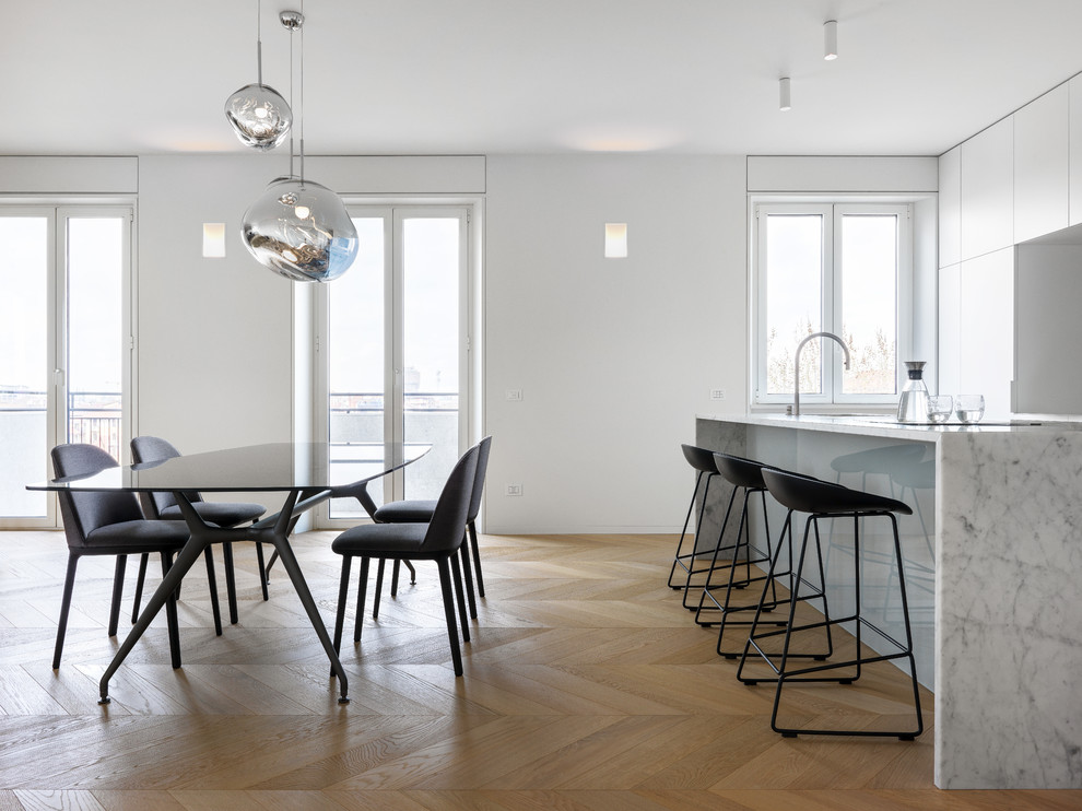 Large modern open plan dining room in Milan with white walls and medium hardwood flooring.