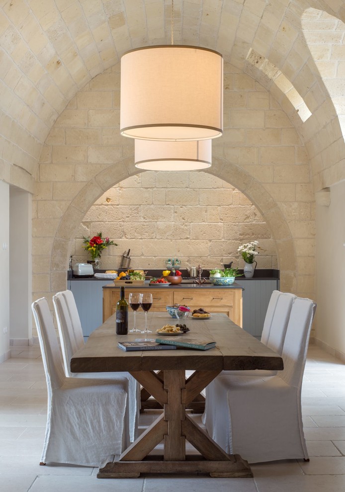 Esempio di una sala da pranzo aperta verso la cucina mediterranea con pareti beige e pavimento grigio