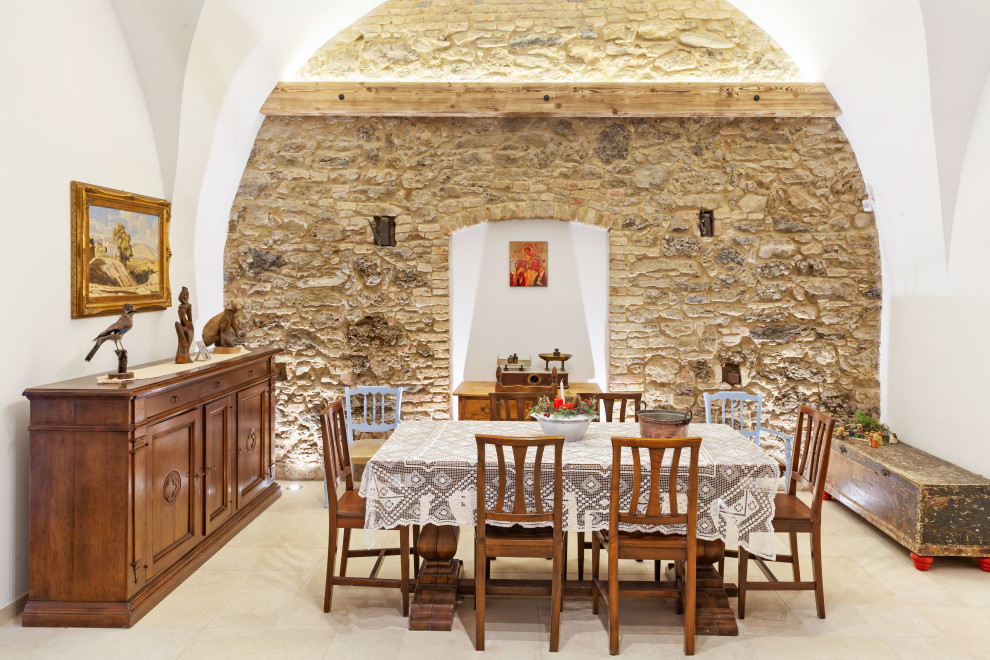 Foto di una sala da pranzo mediterranea con pareti bianche e pavimento beige