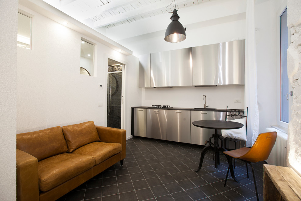 Foto di una piccola sala da pranzo aperta verso il soggiorno industriale con pareti bianche, pavimento in gres porcellanato e pavimento nero