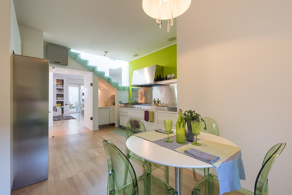 Esempio di una grande sala da pranzo aperta verso la cucina minimal con pareti multicolore e parquet chiaro