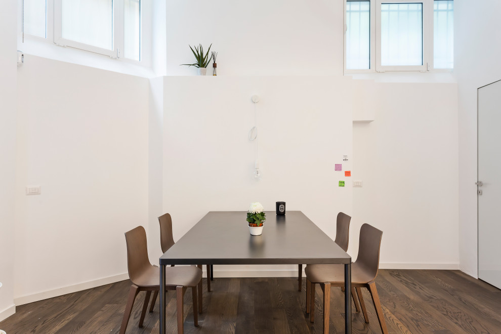 Esempio di una piccola sala da pranzo minimalista con pareti bianche, parquet scuro e pavimento marrone