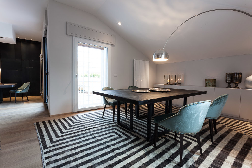 Immagine di una sala da pranzo aperta verso il soggiorno minimal con pareti bianche e parquet chiaro