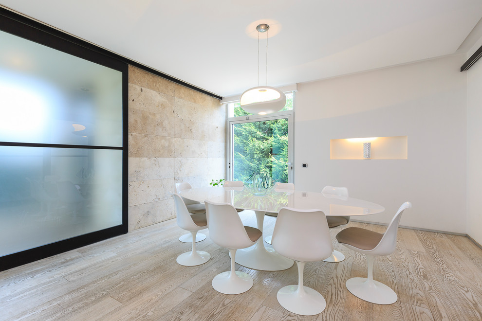 Modernes Esszimmer mit weißer Wandfarbe, beigem Boden und hellem Holzboden in Mailand