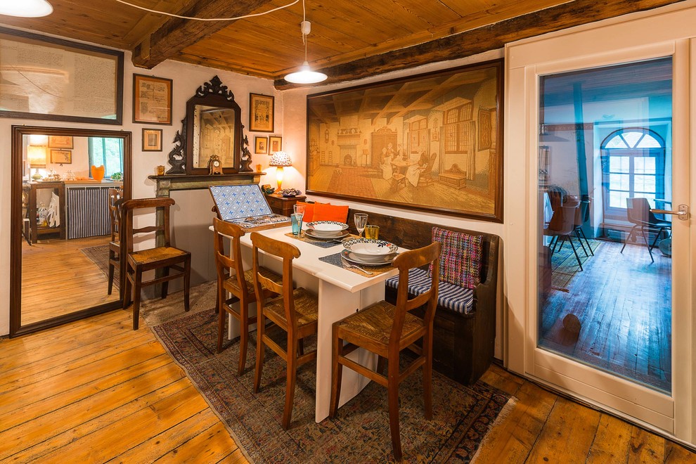 Foto de comedor campestre con paredes blancas y suelo de madera en tonos medios