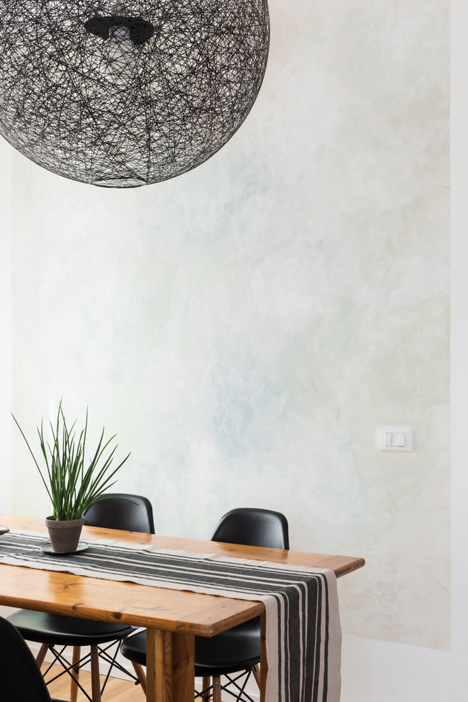 Idée de décoration pour une salle à manger ouverte sur le salon design avec un mur gris, parquet clair et un sol marron.