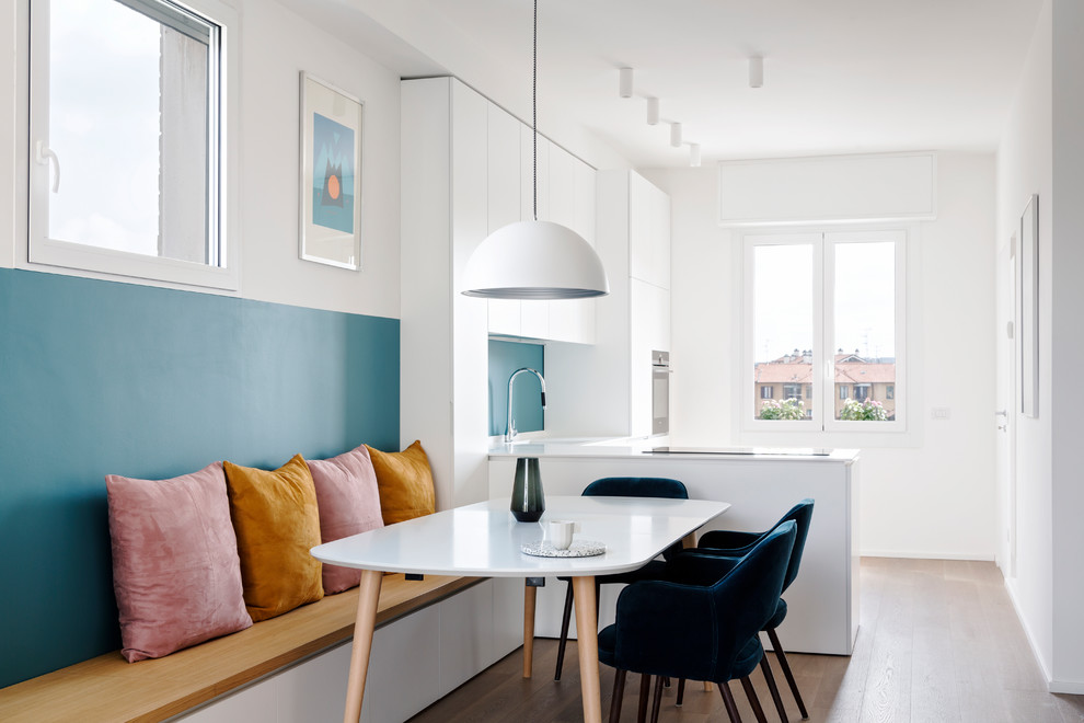 Mittelgroße Moderne Wohnküche mit braunem Holzboden, weißer Wandfarbe und braunem Boden in Mailand