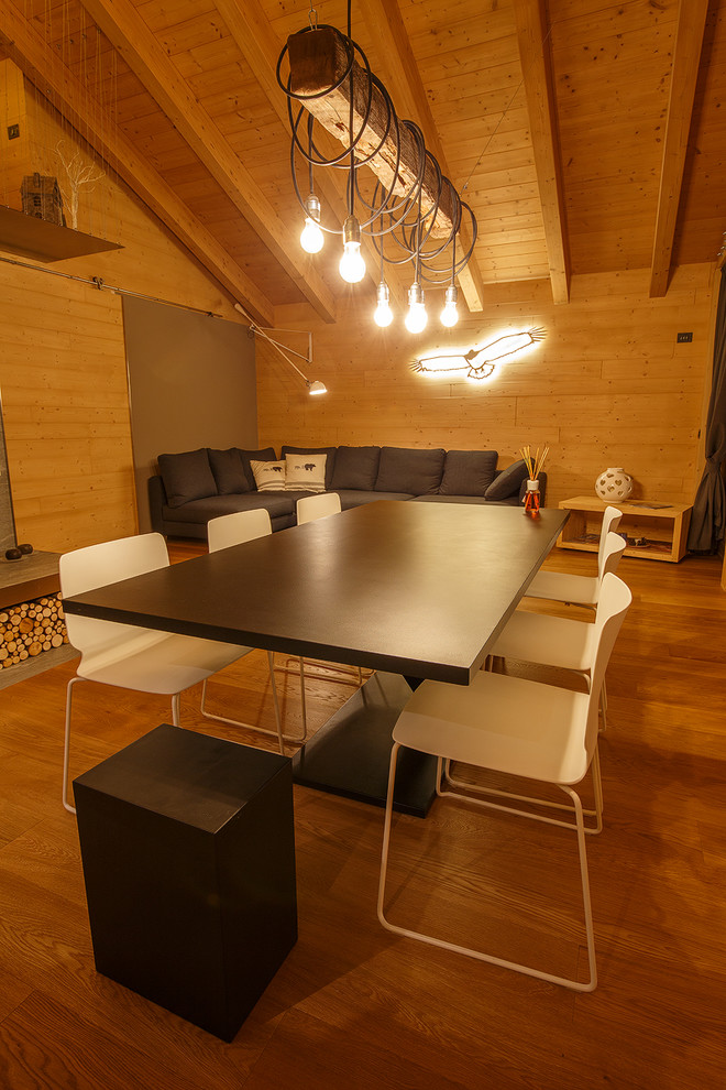 Стильный дизайн: большая гостиная-столовая в стиле рустика с серыми стенами, паркетным полом среднего тона, двусторонним камином, фасадом камина из плитки и коричневым полом - последний тренд