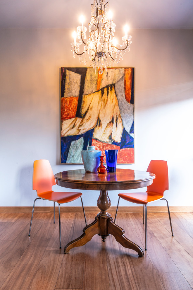 Idées déco pour une salle à manger ouverte sur le salon éclectique de taille moyenne avec un mur gris, parquet peint et un sol marron.