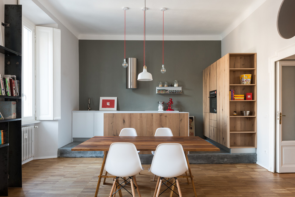 Idee per una sala da pranzo aperta verso il soggiorno minimal con pareti grigie e parquet chiaro