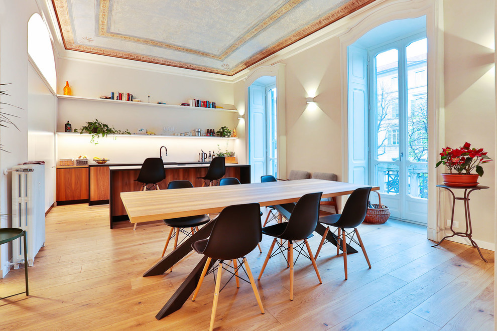 Große Moderne Wohnküche mit weißer Wandfarbe, braunem Holzboden und braunem Boden in Turin