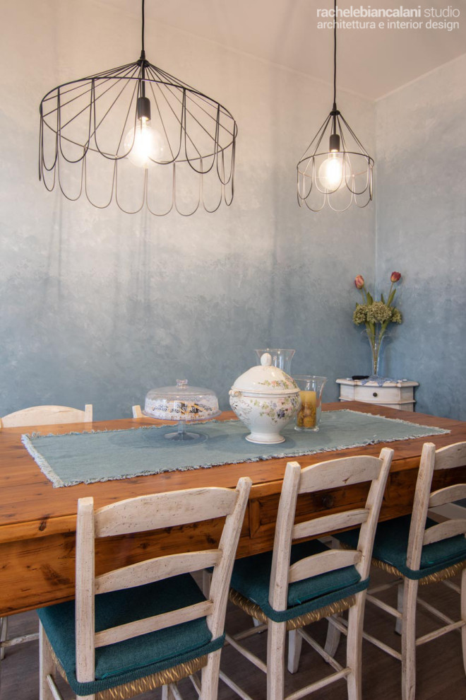 Immagine di una piccola sala da pranzo aperta verso la cucina moderna con pareti blu, parquet chiaro, nessun camino e pavimento marrone