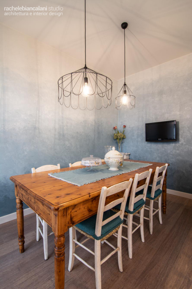Ispirazione per una piccola sala da pranzo aperta verso la cucina tradizionale con pareti blu, parquet chiaro, nessun camino e pavimento marrone
