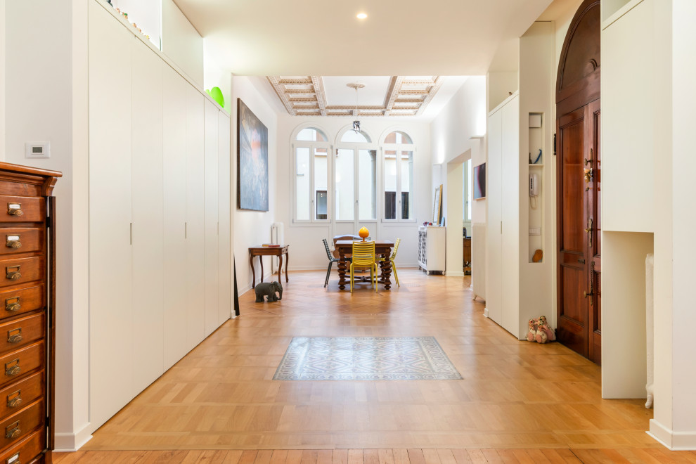 Modelo de comedor moderno grande abierto con paredes blancas, suelo de madera en tonos medios y suelo marrón