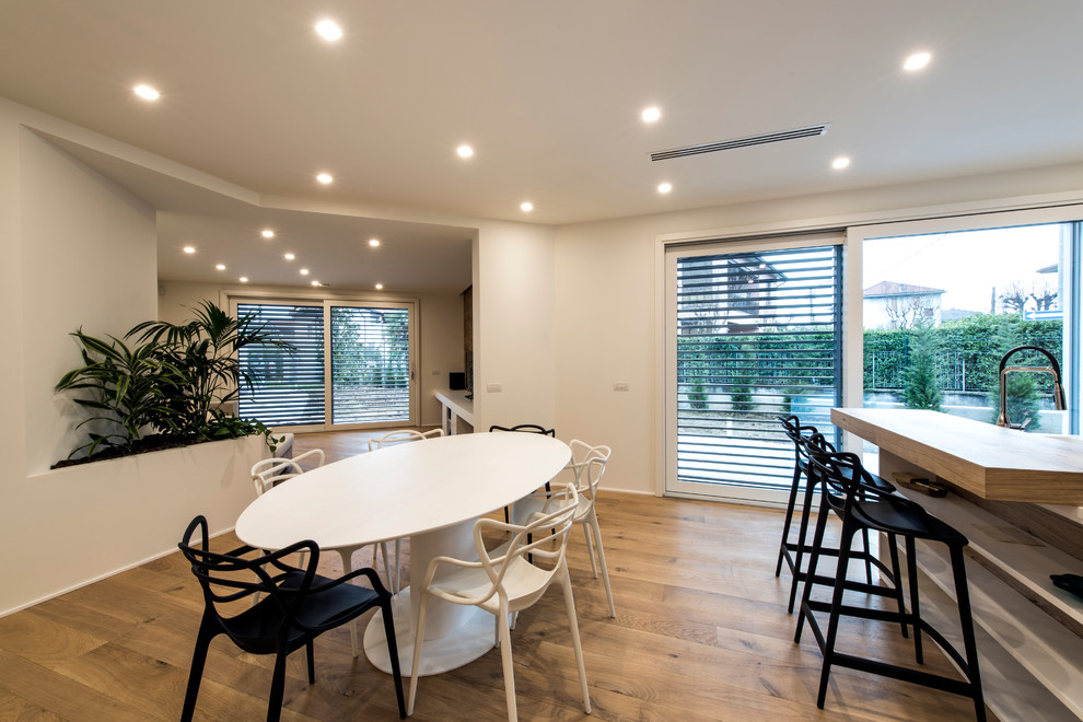 Idee per una grande sala da pranzo aperta verso il soggiorno contemporanea con pareti bianche e pavimento in legno verniciato