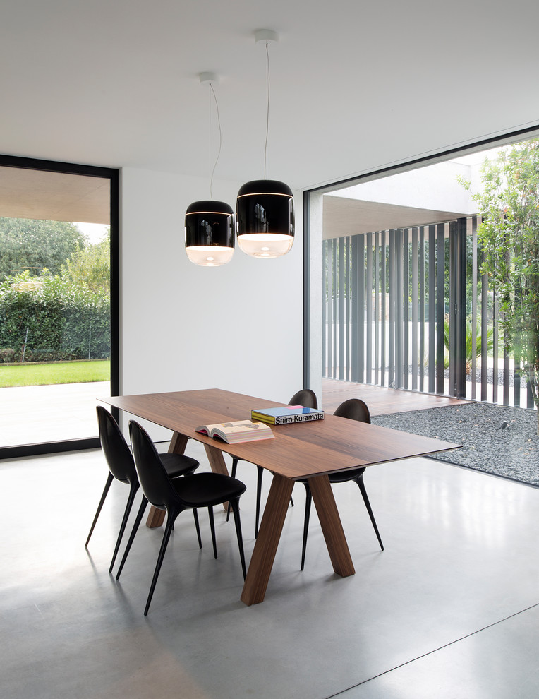 Modern dining room in Venice with white walls, no fireplace and grey floors.