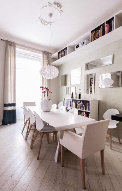 Immagine di una sala da pranzo aperta verso il soggiorno design di medie dimensioni con pareti grigie, parquet chiaro e pavimento marrone