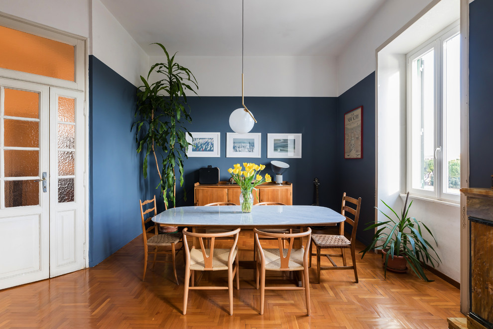 Foto di una sala da pranzo nordica chiusa con pareti blu, pavimento in legno massello medio e pavimento arancione