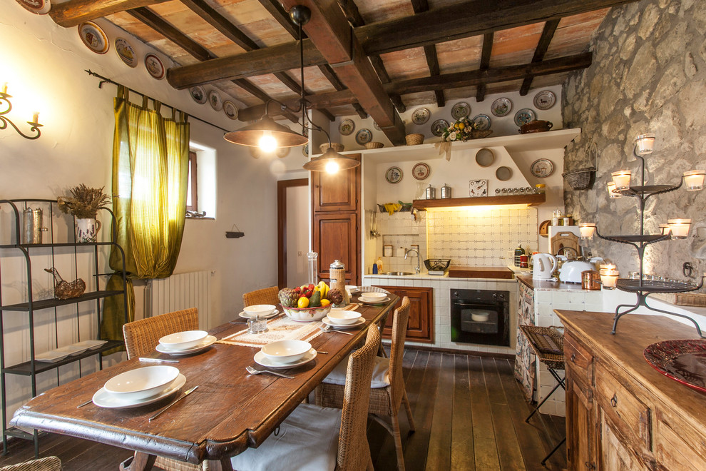 Esempio di una sala da pranzo aperta verso la cucina mediterranea con pareti beige, parquet scuro e pavimento marrone