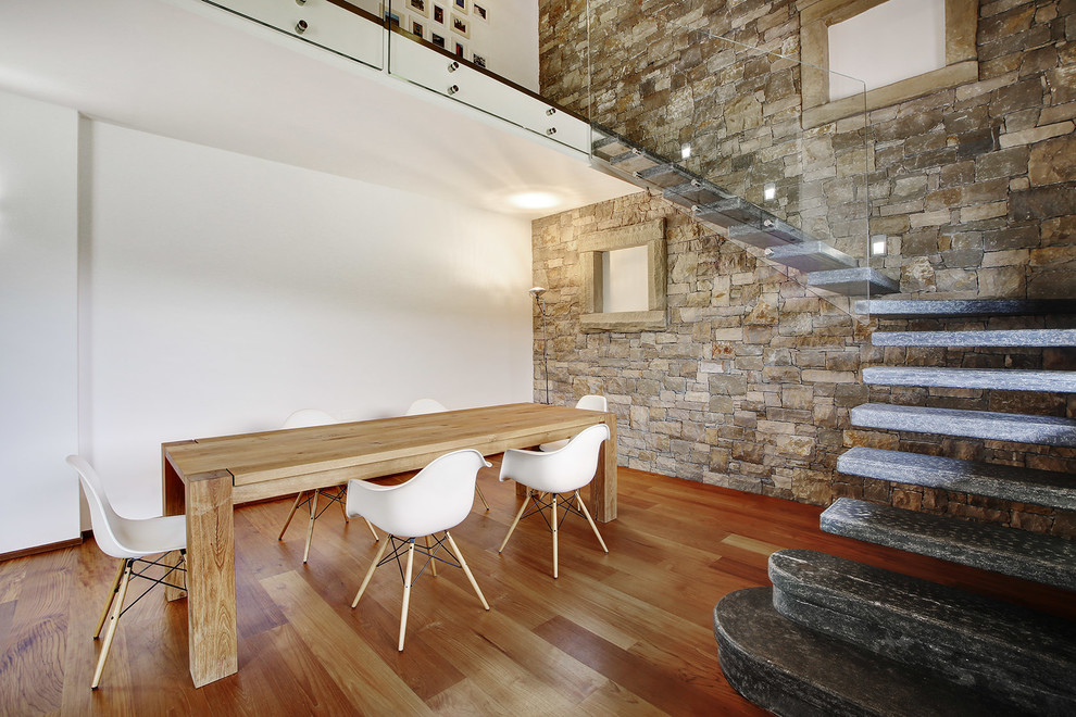 Cette photo montre une salle à manger montagne avec un mur blanc et un sol en bois brun.