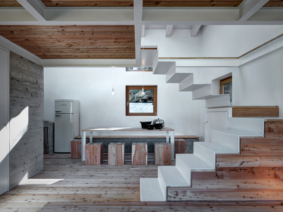 Immagine di una sala da pranzo aperta verso il soggiorno stile rurale di medie dimensioni con pareti bianche, pavimento in legno massello medio e pavimento marrone