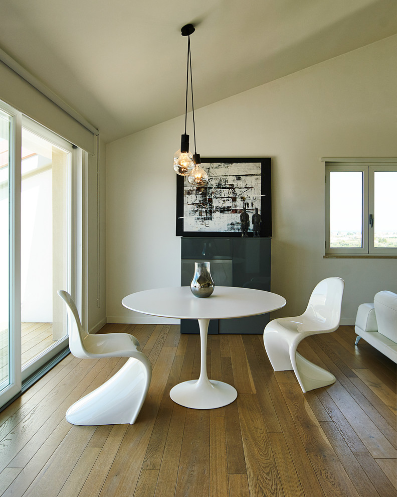 Modern open plan dining room with white walls and medium hardwood flooring.
