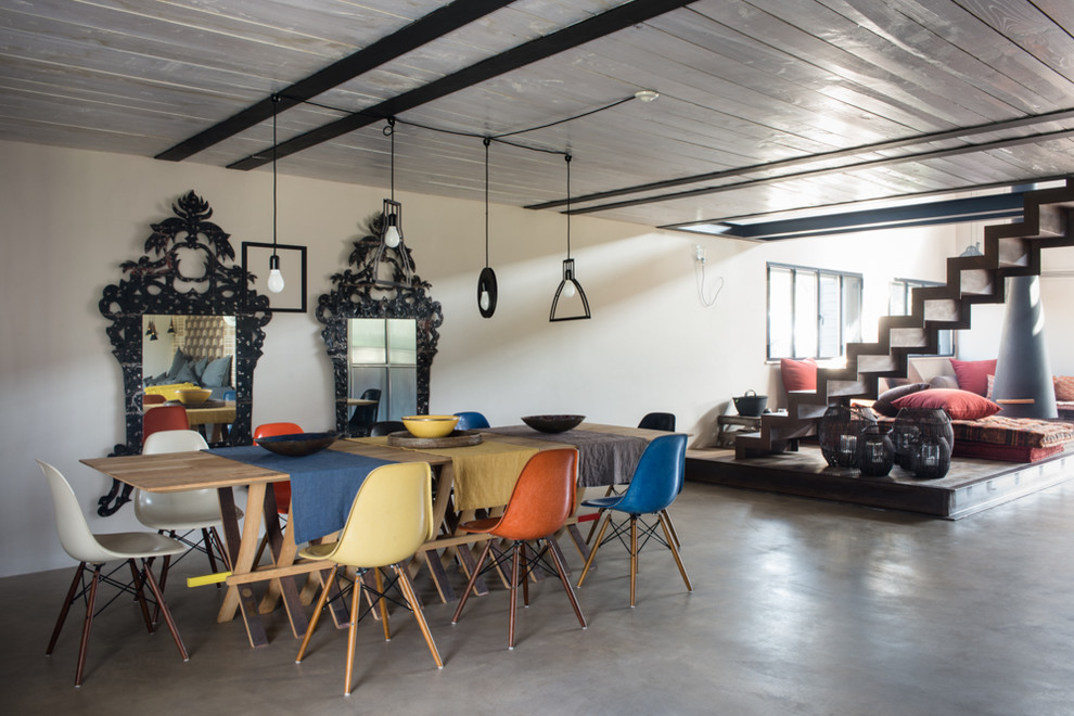 Idee per una sala da pranzo aperta verso il soggiorno industriale con camino sospeso
