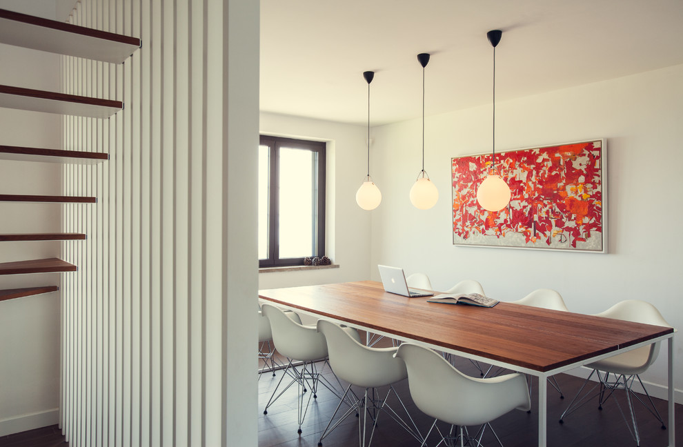 Inspiration pour une salle à manger ouverte sur le salon design avec un mur blanc et parquet foncé.