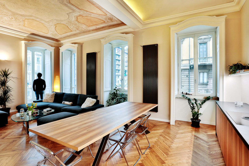 Foto di una sala da pranzo aperta verso il soggiorno tradizionale di medie dimensioni con pareti gialle, pavimento in legno massello medio e pavimento marrone