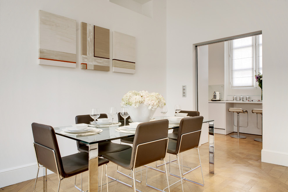 Immagine di una sala da pranzo minimal chiusa con pareti bianche e parquet chiaro