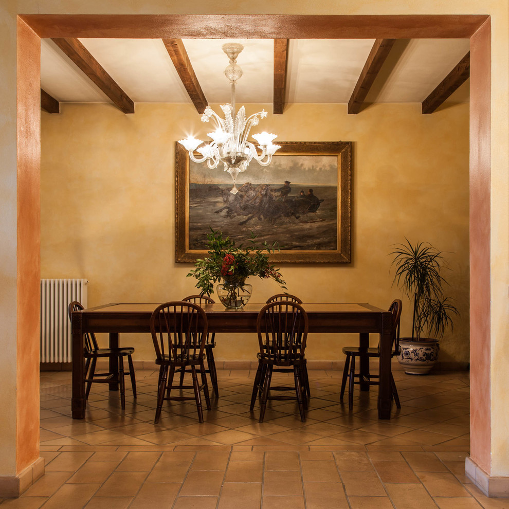 Ispirazione per una grande sala da pranzo aperta verso il soggiorno country con pareti gialle e pavimento in terracotta