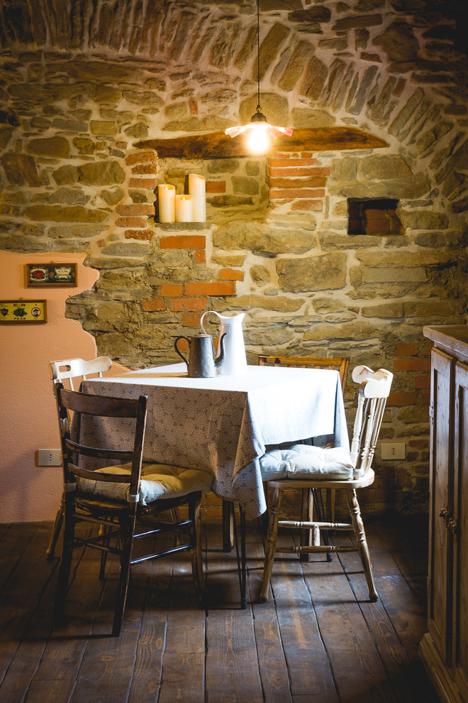 Immagine di una piccola sala da pranzo aperta verso il soggiorno country con parquet scuro e pavimento marrone