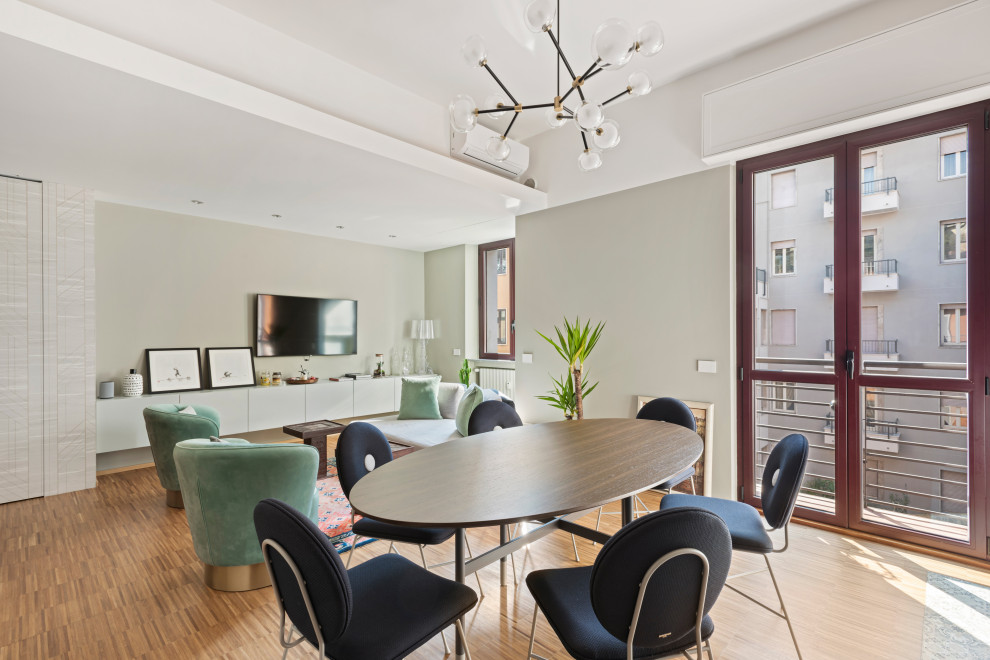 Foto di una sala da pranzo aperta verso il soggiorno minimal con pareti grigie, pavimento in legno massello medio e pavimento marrone