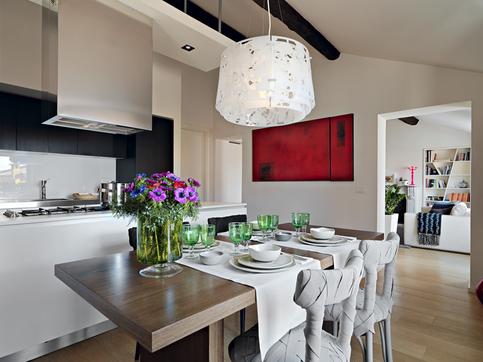 Foto di una sala da pranzo aperta verso la cucina design con pareti bianche e parquet chiaro